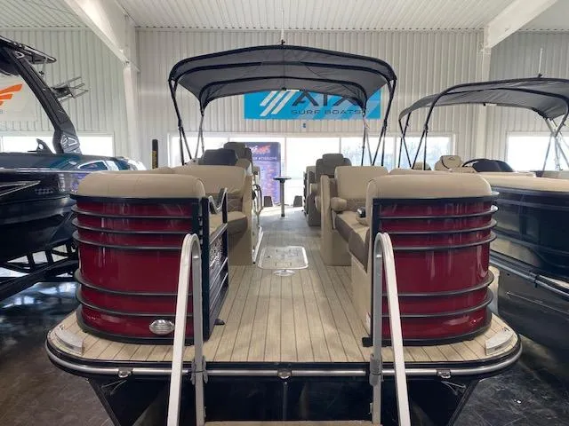 Slide: The Image of 2025 SunCatcher Elite 324 RC pontoon boat in showroom, featuring spacious seating and canopy. - 1