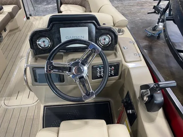 Slide: The Image of 2025 SunCatcher Elite 324 RC boat dashboard with Garmin navigation system and steering wheel. - 7