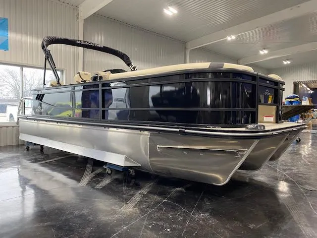 Slide: The Image of 2025 SunCatcher Select 322RF pontoon boat in showroom, sleek design, black and silver finish. - 1