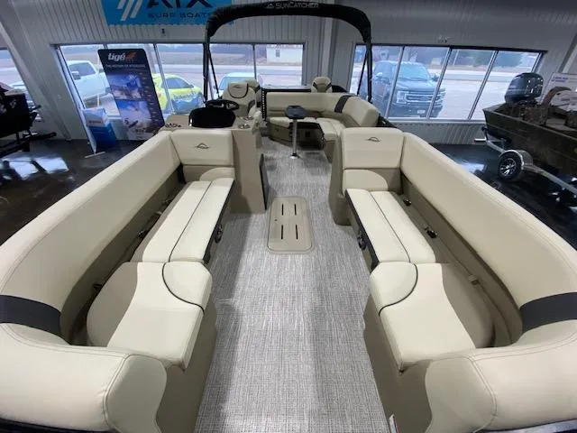 Slide: The Image of 2025 SunCatcher Select 322RF pontoon boat interior with beige seating and spacious layout. - 5