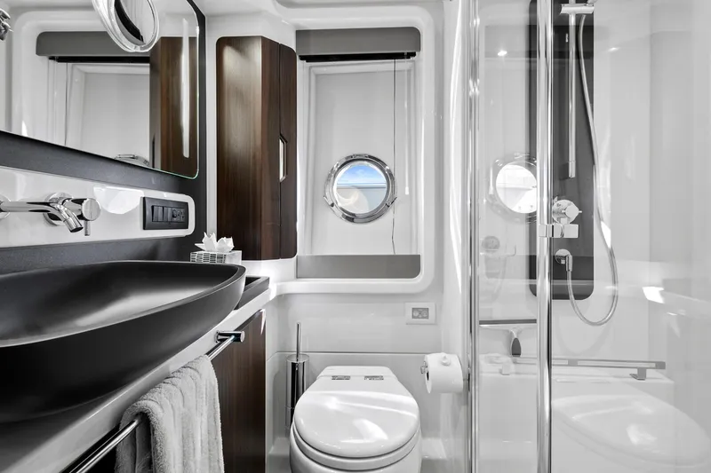 Slide: The Image of Luxurious bathroom in 2019 Azimut 50 Flybridge yacht with modern fixtures and porthole window. - 18