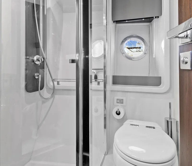 Slide: The Image of Luxurious bathroom in 2019 Azimut 50 Flybridge yacht with modern fixtures and porthole window. - 25