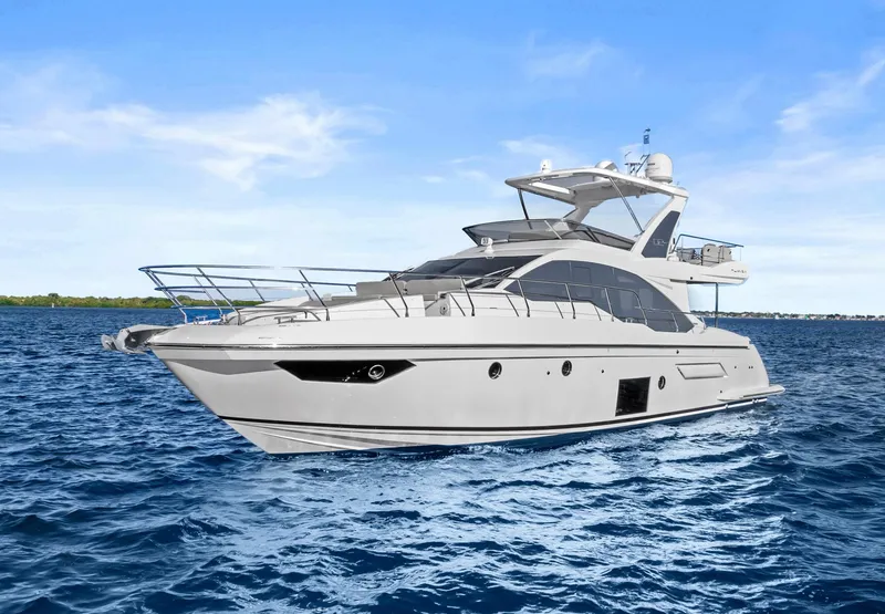 Slide: The Image of 2019 Azimut 50 Flybridge yacht cruising on open water under a clear blue sky. - 3