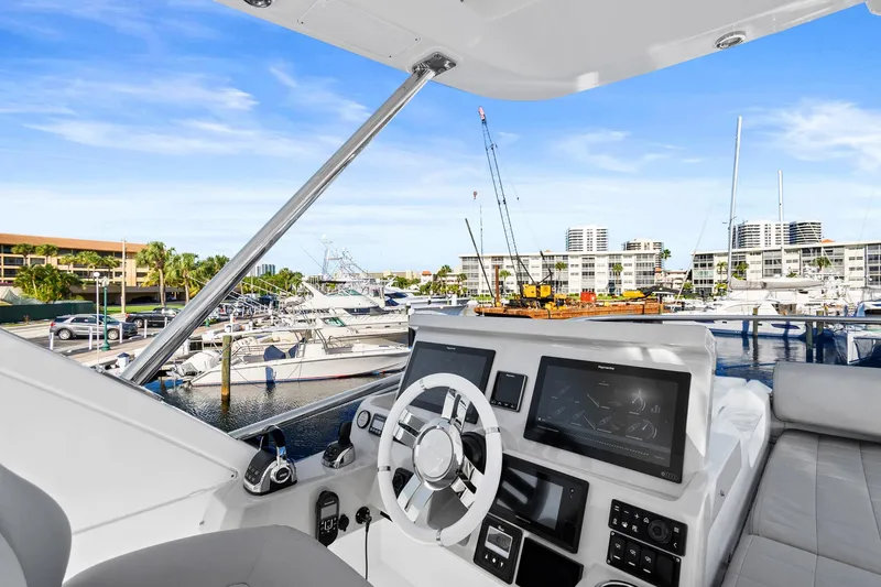 Slide: The Image of 2019 Azimut 50 Flybridge yacht helm with marina view. - 31