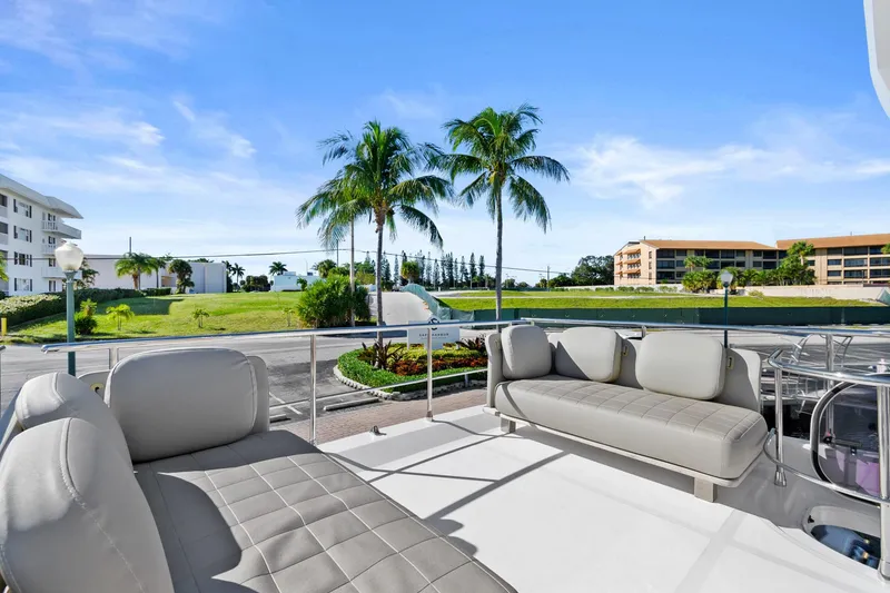 Slide: The Image of Azimut 50 Flybridge 2019 yacht deck with seating, overlooking palm trees and buildings. - 33
