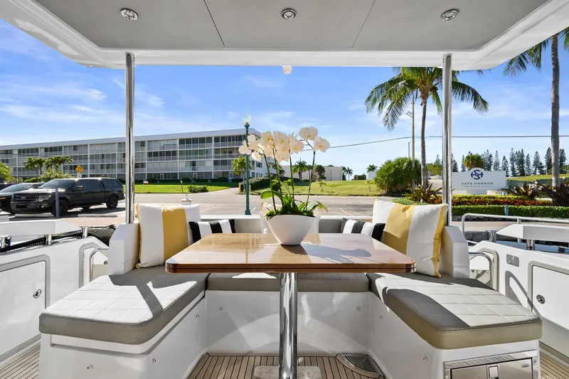 Slide: The Image of 2019 Azimut 50 Flybridge yacht interior with elegant seating and table, featuring a floral centerpiece. - 42
