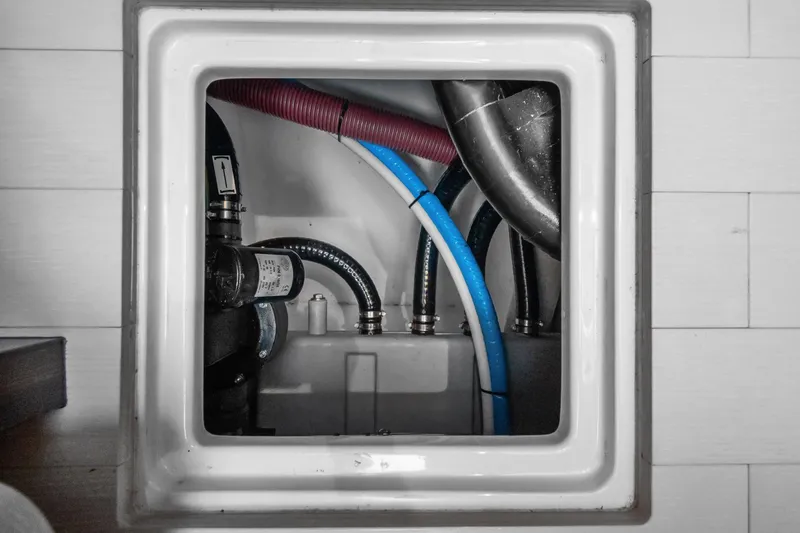 Slide: The Image of Engine compartment of a 2019 Azimut 50 Flybridge yacht, showing various hoses and fittings. - 48