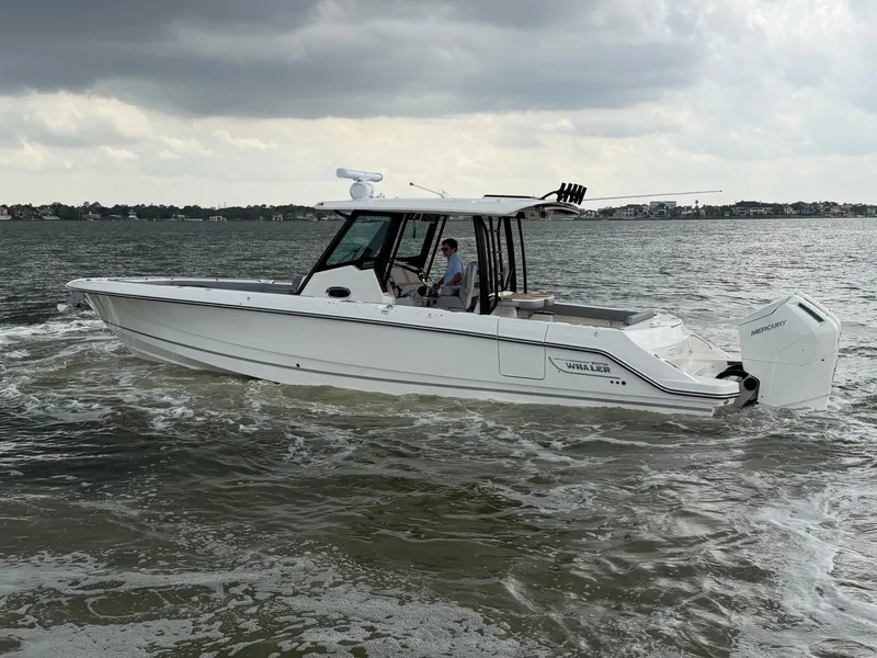 Slide: The Image of Boston Whaler 360 Outrage 2026 on water under cloudy skies. - 12