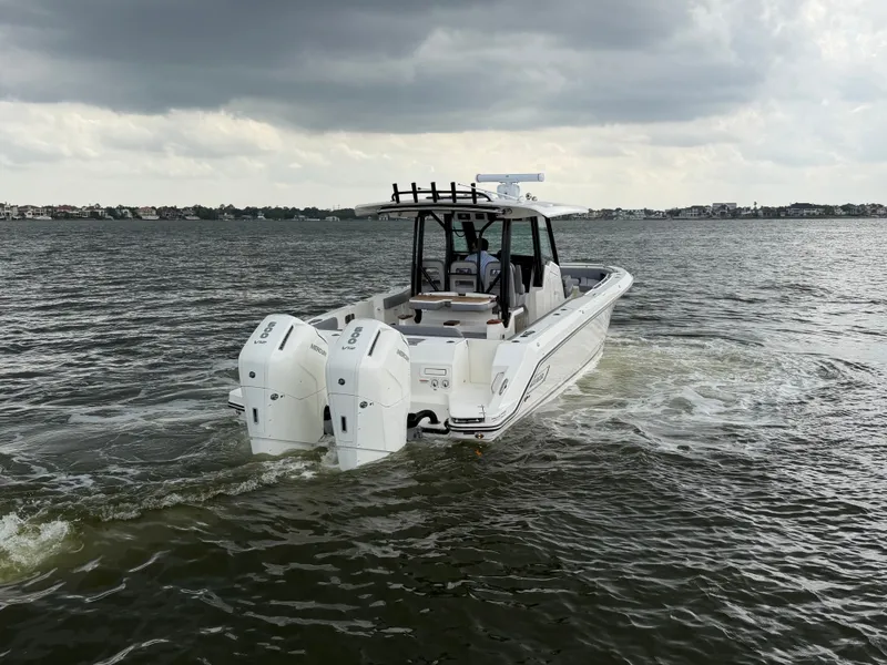 Slide: The Image of Boston Whaler 360 Outrage 2026 on water under cloudy skies. - 8