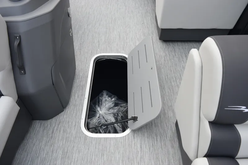 Slide: The Image of 2025 Bennington 21 SL boat interior with open storage compartment on gray carpeted floor. - 13