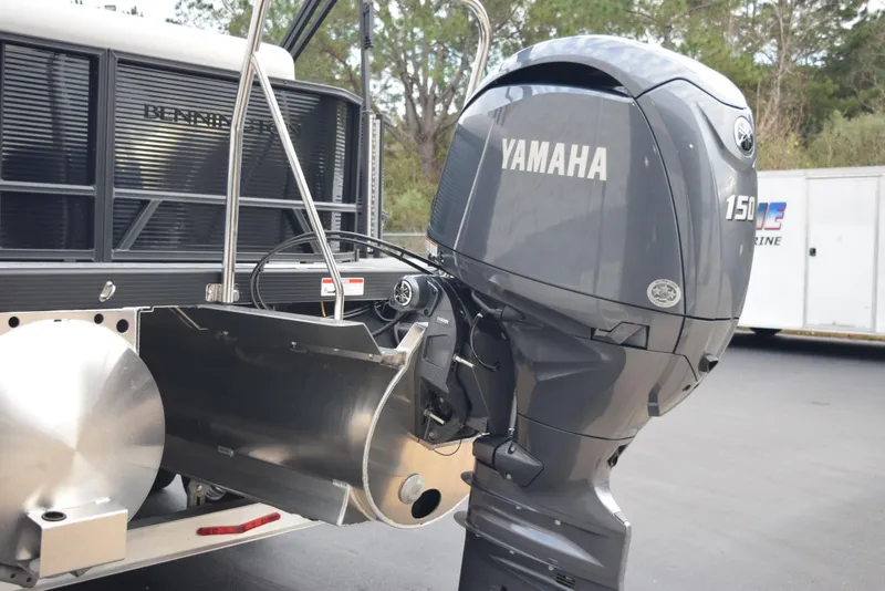 Slide: The Image of 2025 Bennington 21 SL with Yamaha 150 outboard motor, parked outdoors. - 6