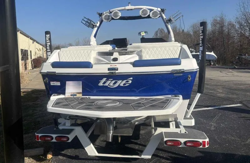 Slide: The Image of 2024 Tigé Z5 boat, rear view, blue and white design, parked outdoors. - 3