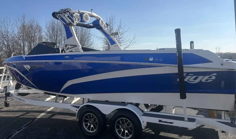 Slide: The Image of 2024 Tigé Z5 boat in blue on a trailer, parked outdoors. - 4
