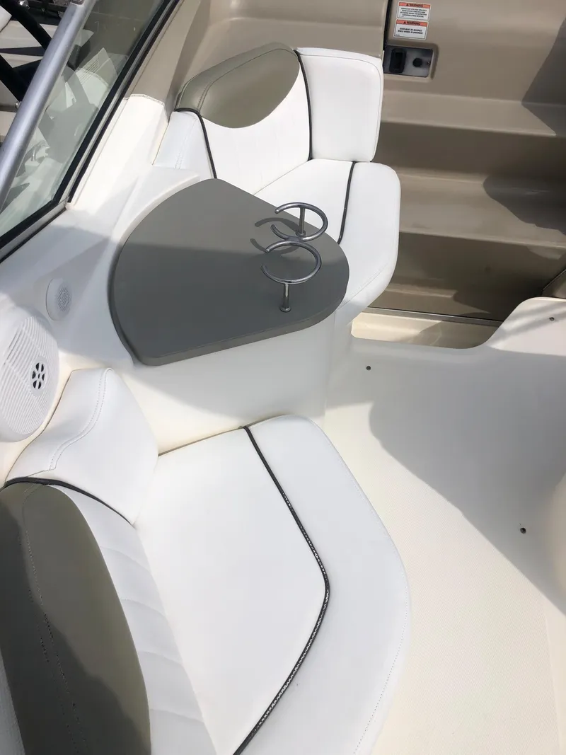 Slide: The Image of 2007 Sea Ray 240 Sundancer interior with white seating and a small table. - 10