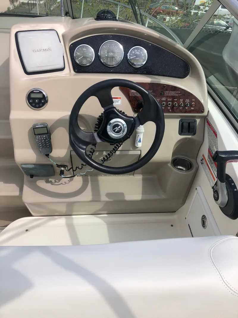 Slide: The Image of 2007 Sea Ray 240 Sundancer helm with steering wheel and control panel. - 11