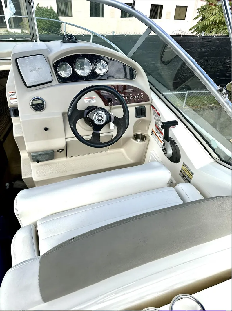 Slide: The Image of 2007 Sea Ray 240 Sundancer boat cockpit with steering wheel and dashboard controls. - 26