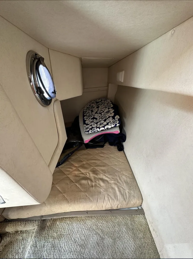 Slide: The Image of Interior cabin of 2007 Sea Ray 240 Sundancer with bedding and porthole. - 29
