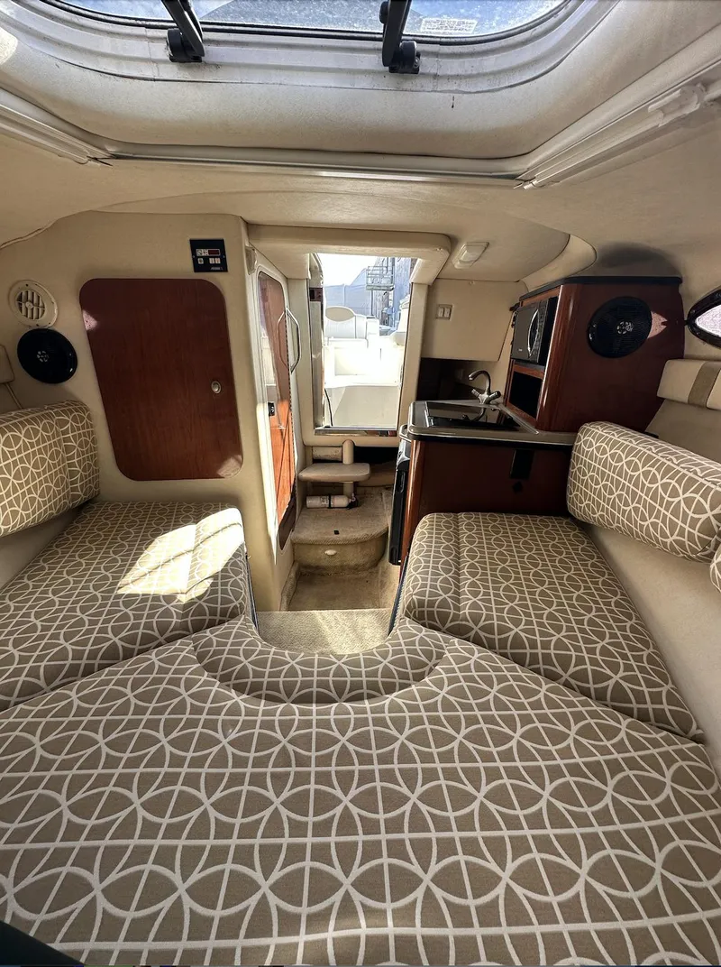 Slide: The Image of Interior of 2007 Sea Ray 240 Sundancer with patterned seating and compact kitchenette. - 30