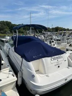Slide: The Image of 2007 Sea Ray 240 Sundancer boat docked with blue canopy in a marina. - 36