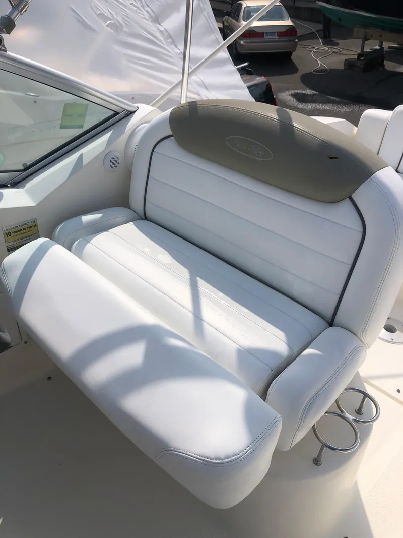 Slide: The Image of 2007 Sea Ray 240 Sundancer boat seat with white upholstery and cup holders. - 4