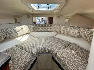 Slide: The Image of 2007 Sea Ray 240 Sundancer cabin interior with patterned cushions and overhead hatch. - 42