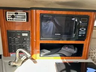 Slide: The Image of 2007 Sea Ray 240 Sundancer interior with microwave, control panel, and storage area. - 44