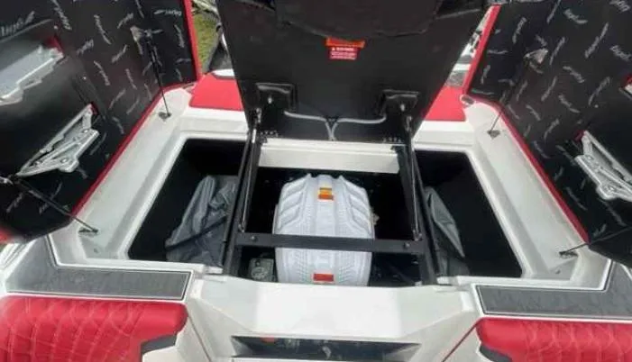 Slide: The Image of 2024 Tigé 24RZX boat storage compartments with open lids and visible interior. - 10