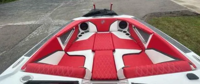 Slide: The Image of 2024 Tigé 24RZX boat interior with red and white seating and speakers. - 7