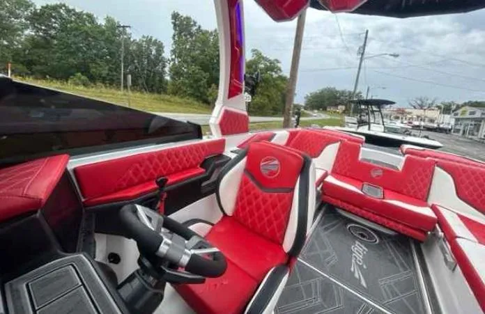 Slide: The Image of 2024 Tigé 24RZX boat interior with red and white seating, steering wheel, and modern design. - 8