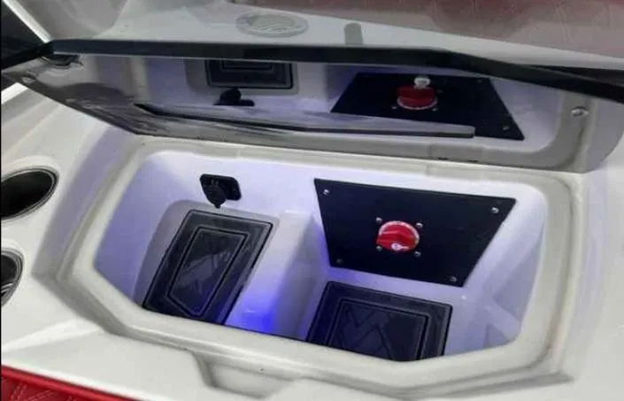 Slide: The Image of 2024 Tigé 24RZX boat storage compartment with battery switch and cup holders. - 9