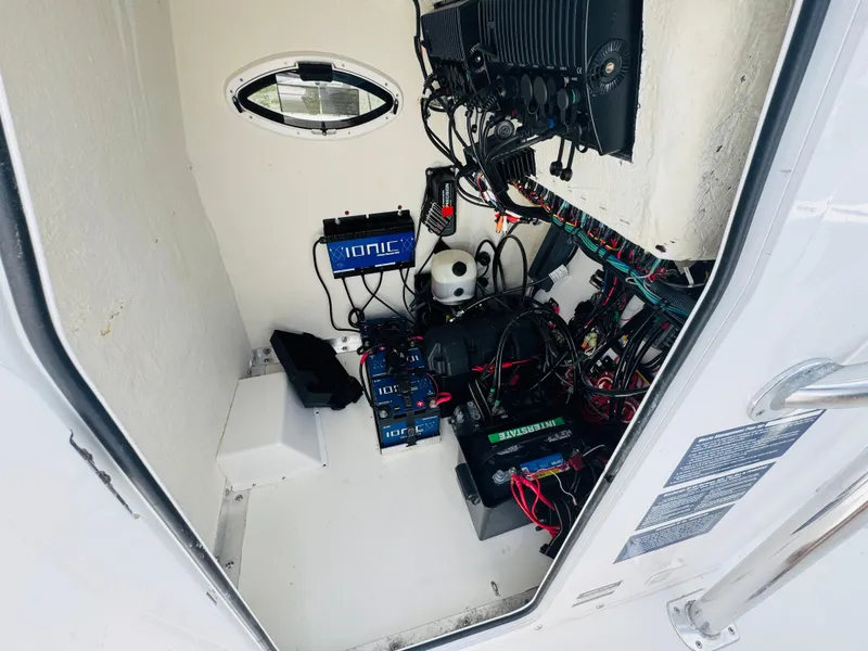 Slide: The Image of Electrical compartment of 2022 Twin Vee 310 CC GF Classic boat, featuring wiring and battery systems. - 21