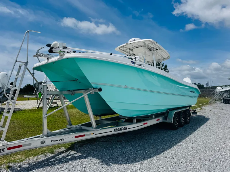 Slide: The Image of 2022 Twin Vee 310 CC GF Classic boat on trailer, turquoise hull, sunny day. - 3