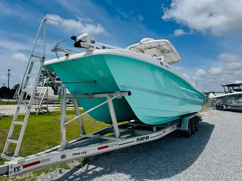 Slide: The Image of 2022 Twin Vee 310 CC GF Classic boat on trailer, turquoise hull, outdoor display. - 4