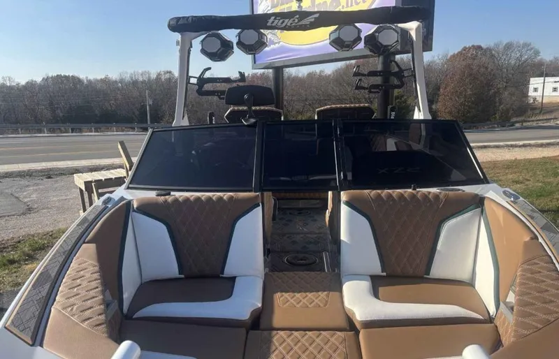 Slide: The Image of 2024 Tigé 22RZX boat with brown and white interior, parked outdoors. - 8