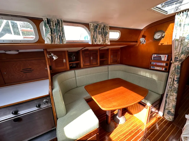 Slide: The Image of 1978 Hinckley Bermuda 40 MK III yacht interior with cozy dining area and wooden finishes. - 23