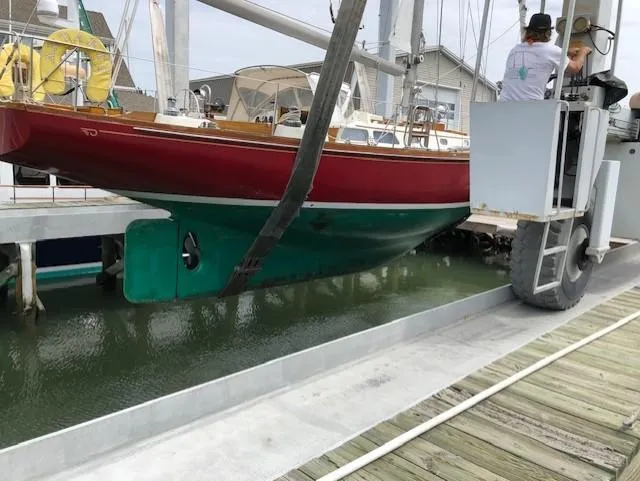 Slide: The Image of 1978 Hinckley Bermuda 40 MK III sailboat being lifted from the water at a marina. - 26