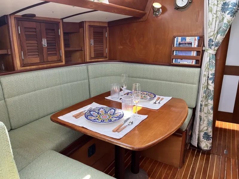Slide: The Image of Cozy dining area in a 1978 Hinckley Bermuda 40 MK III sailboat, featuring elegant wood finishes. - 3