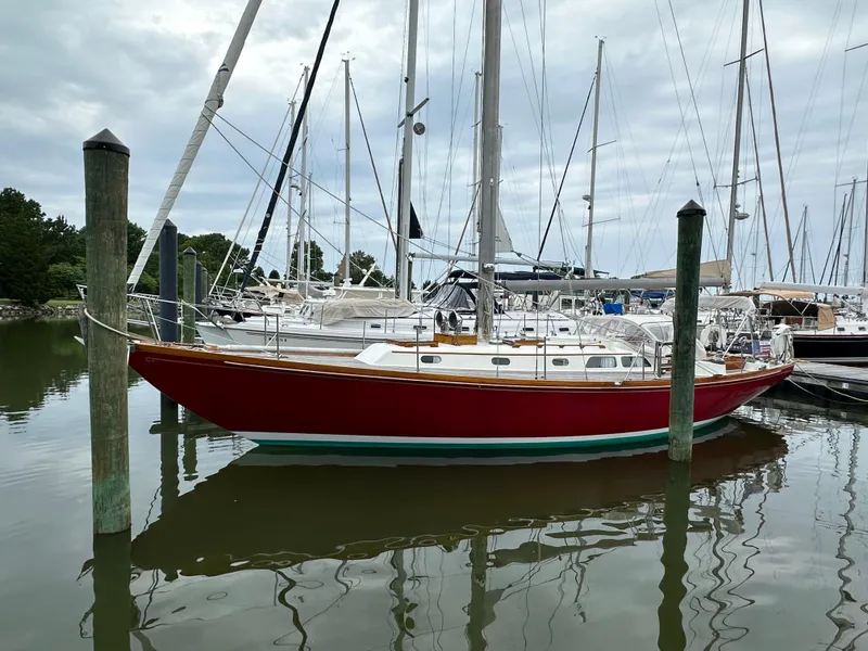 Slide: The Image of 1978 Hinckley Bermuda 40 MK III sailboat docked in a marina, reflecting on calm water. - 30