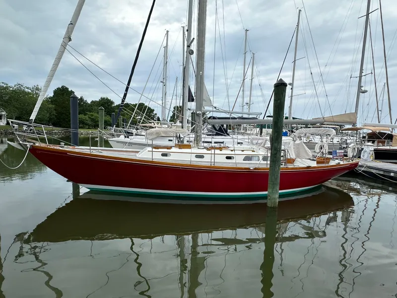 Slide: The Image of 1978 Hinckley Bermuda 40 MK III sailboat docked in a marina, featuring a red hull. - 31
