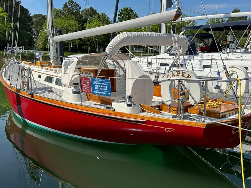 Slide: The Image of 1978 Hinckley Bermuda 40 MK III sailboat with red hull docked in marina. - 32