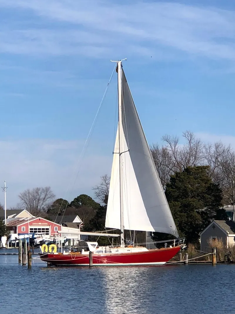 Slide: The Image of 1978 Hinckley Bermuda 40 MK III sailboat docked by waterfront homes. - 5