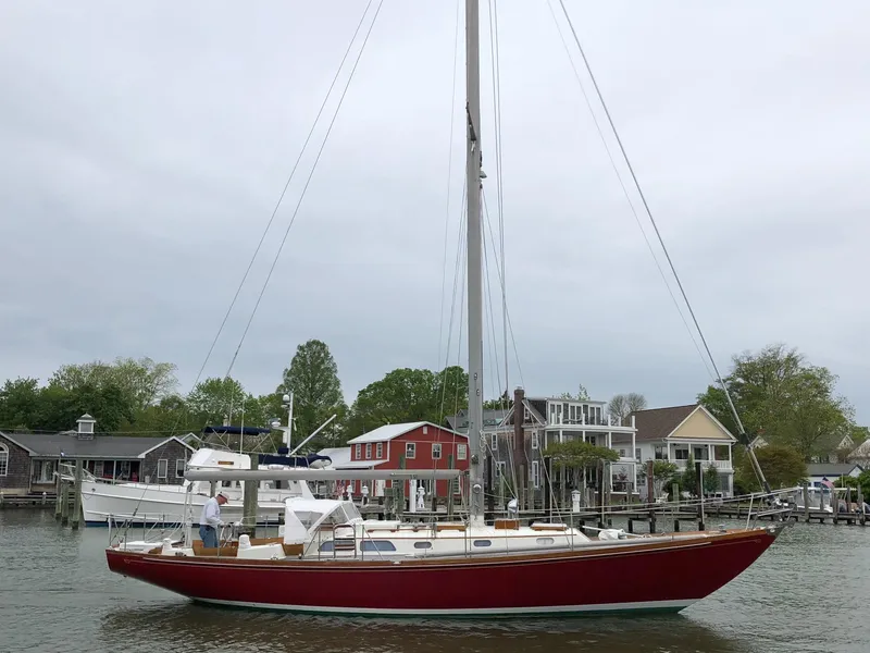 Slide: The Image of 1978 Hinckley Bermuda 40 MK III sailboat docked near waterfront homes. - 6