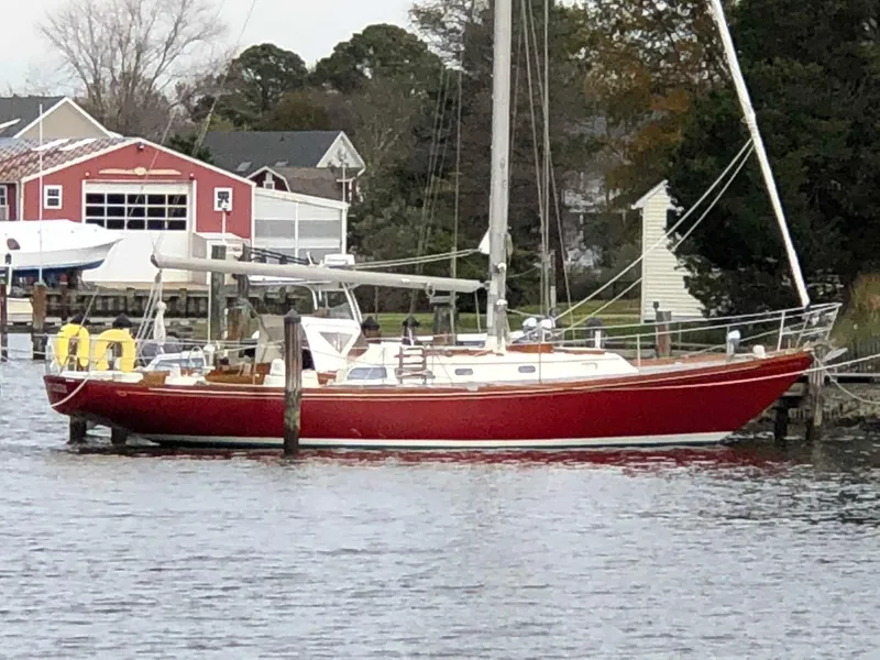 Slide: The Image of 1978 Hinckley Bermuda 40 MK III sailboat docked by waterfront homes. - 8