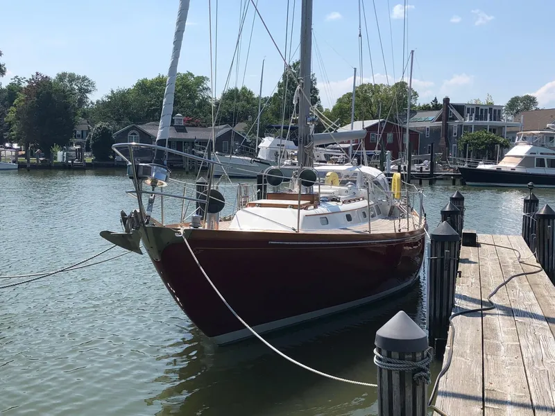 Slide: The Image of 1978 Hinckley Bermuda 40 MK III sailboat docked in a serene marina setting. - 9