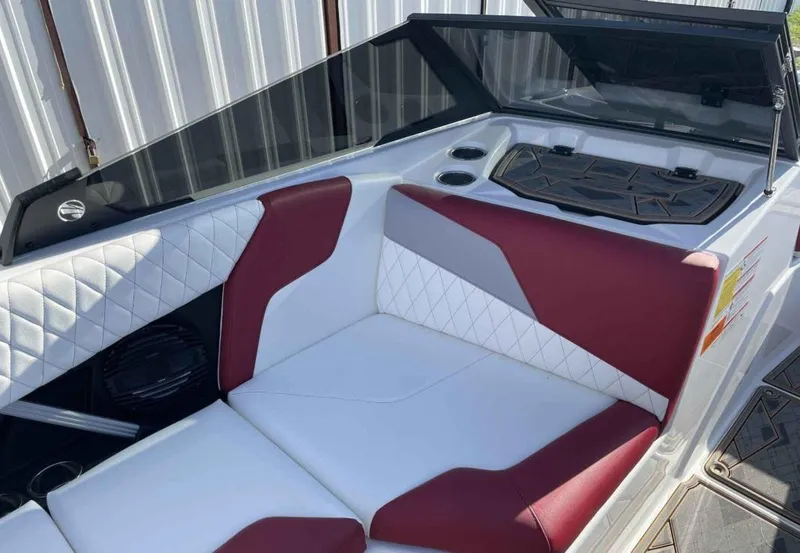 Slide: The Image of 2024 Tigé Z3 boat interior with red and white seating, diamond stitching, and cup holders. - 7