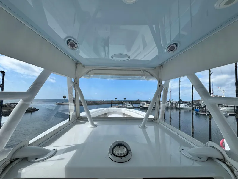 Slide: The Image of 2016 Invincible 39' Open Fisherman boat at marina, showcasing helm and ocean view. - 17