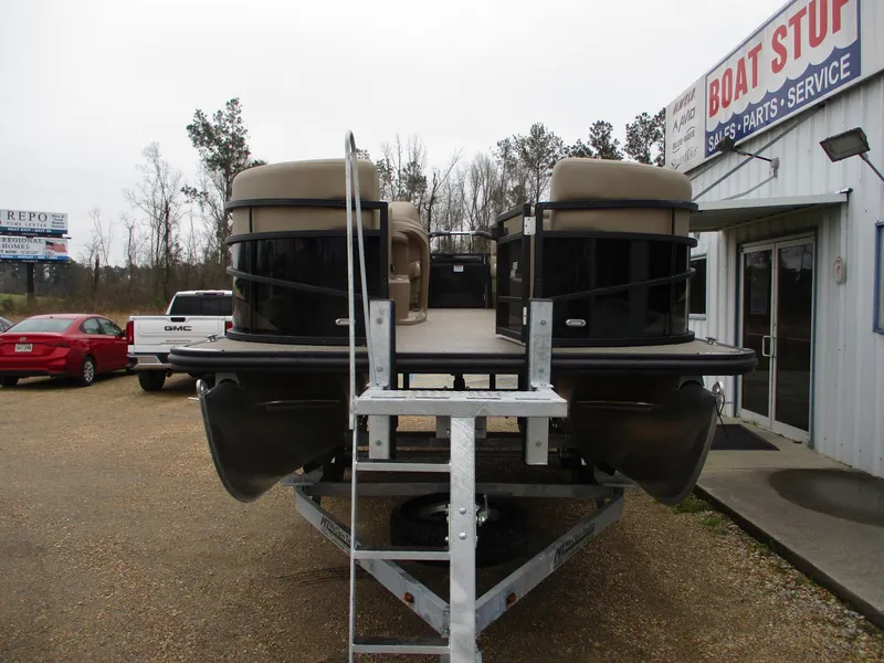 Slide: The Image of 2025 Starcraft LX20 R pontoon boat on trailer at dealership. - 2