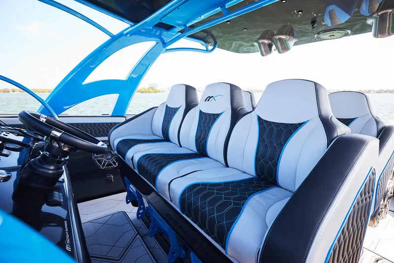 Slide: The Image of 2023 Midnight Express 43' Solstice boat interior with modern seating and steering wheel. - 18