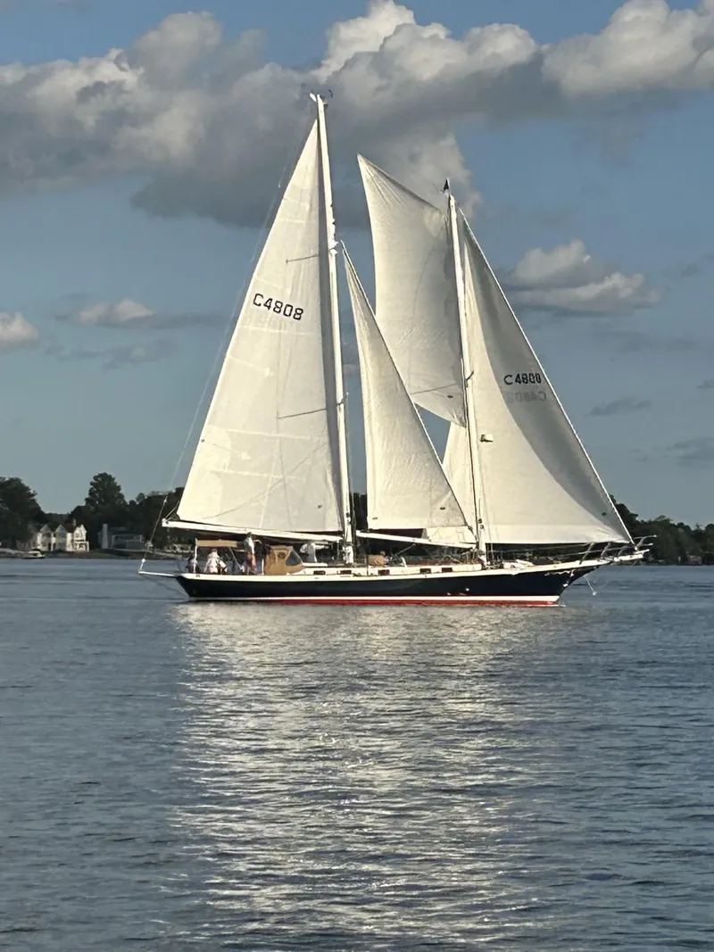 Slide: The Image of Cherubini Schooner 2000 sailing on calm waters under a partly cloudy sky. - 1