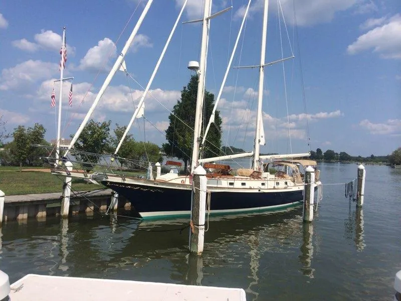 Slide: The Image of Cherubini Schooner 2000 docked by a scenic waterfront under a blue sky. - 5